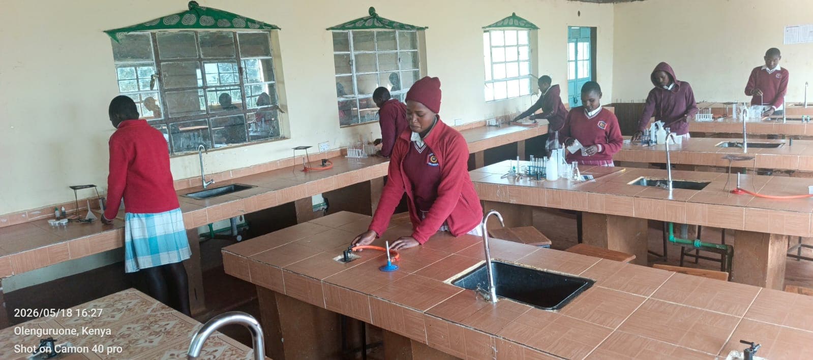 Students running chemistry practicals at laboratory benches